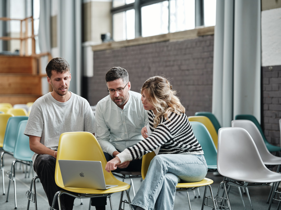 Startup Gründer:innen sitzen zusammen und brainstormen.