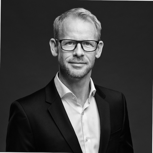Schwarz-Weiß-Portrait eines Mannes mit leichtem Bart und Brille