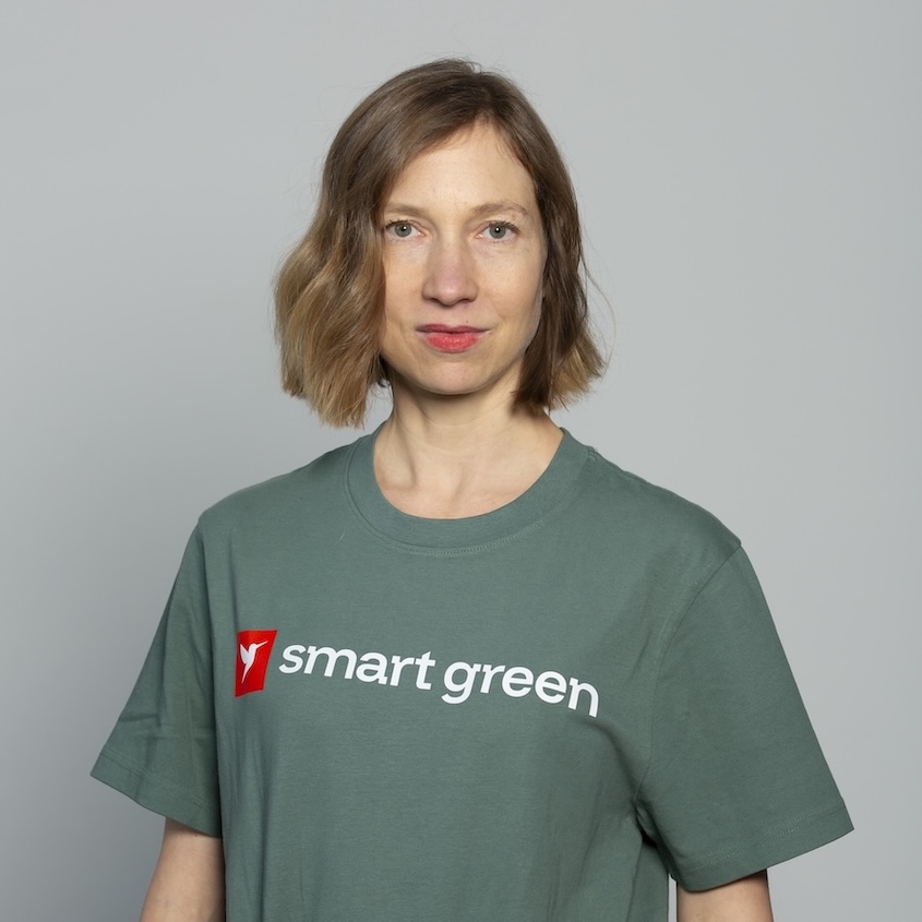 Andrea Bailey schaut in die Kamera und trägt ein grünes Shirt.