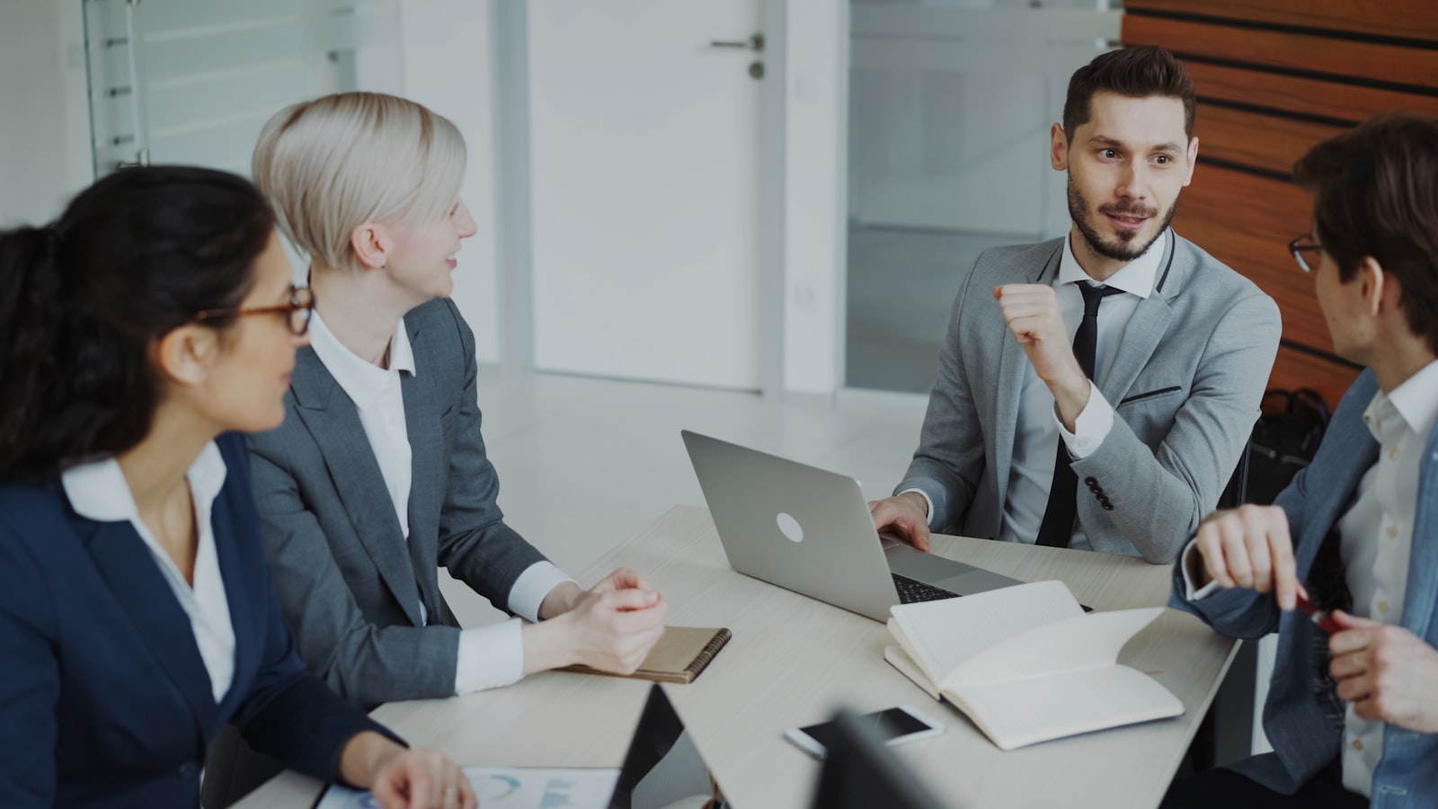 Quatre professionnels en réunion autour d'une table