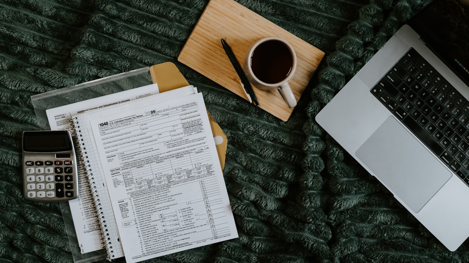 Ordinateur portable, documents et calculatrice sur un bureau de freelance