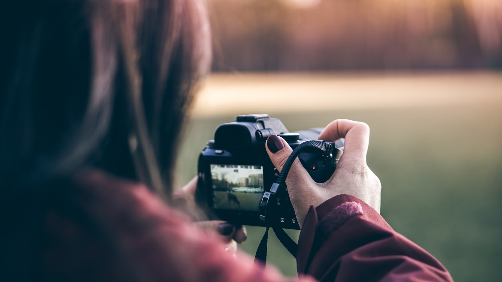 Vidéaste tenant une caméra reflex en tournage