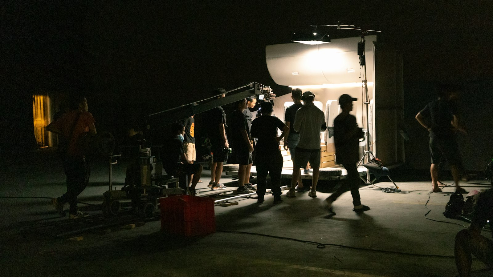 Équipe de tournage autour d'une caméra dans un décor sombre