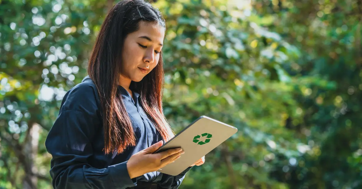 ESG software companies highlighted by a woman using a tablet with a recycling symbol, promoting green technology