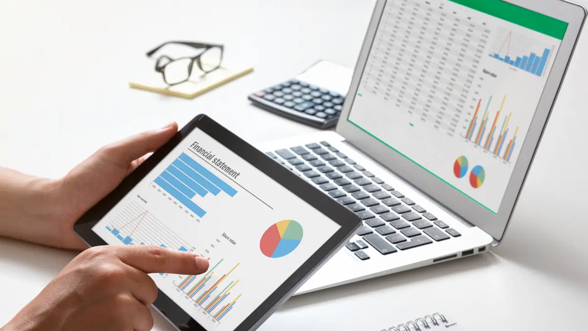 Real-time monitoring of supply chains displayed with financial graphs and charts on a tablet and laptop