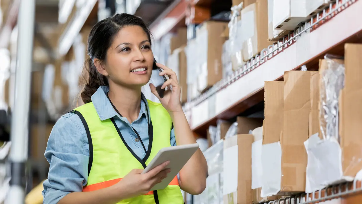 Compliance tools for suppliers used by a warehouse worker managing inventory with a tablet and phone