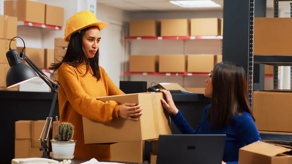 Best TPRM tools discussed by warehouse employees collaborating on package handling.