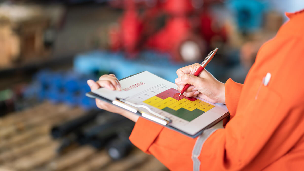 Worker writing on a Risk Assessment chart