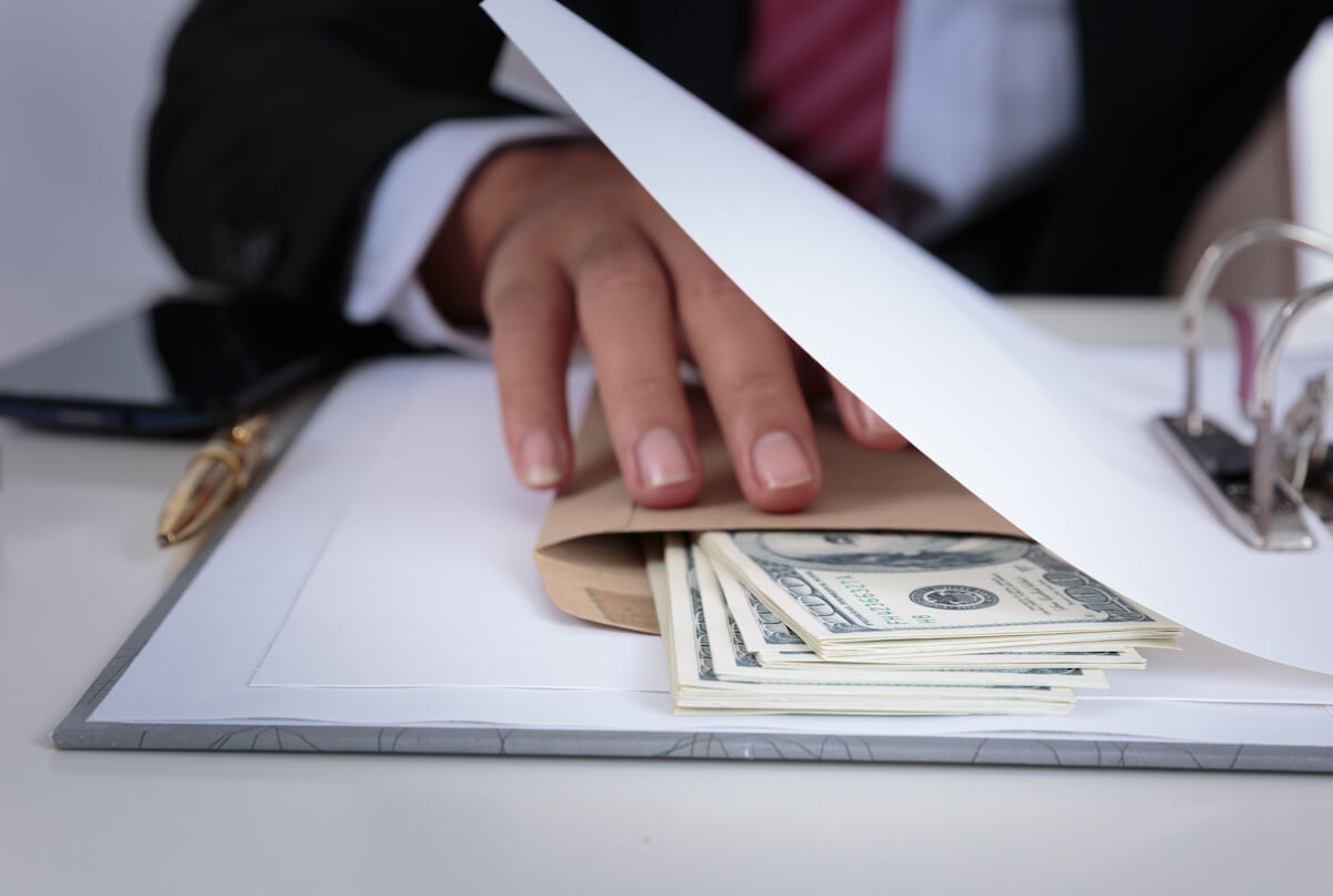 FCPA compliance: entrepreneur holding an envelope with bills