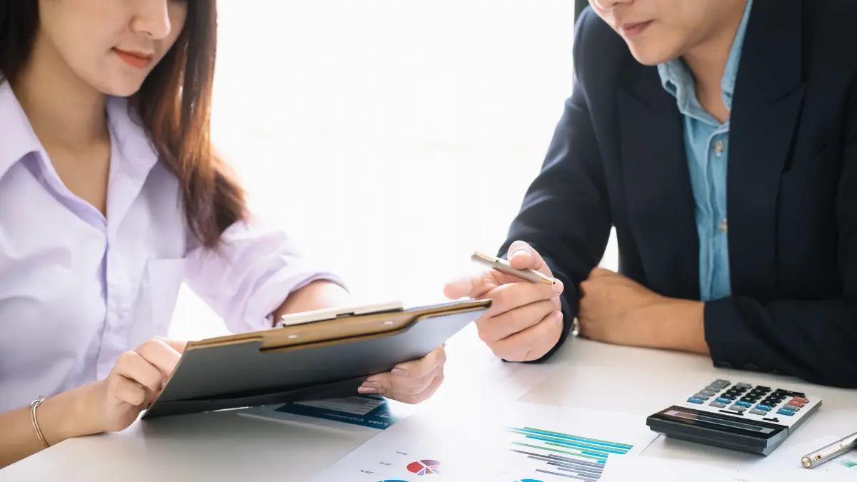 Unified risk management strategy discussed between two professionals using financial data charts.