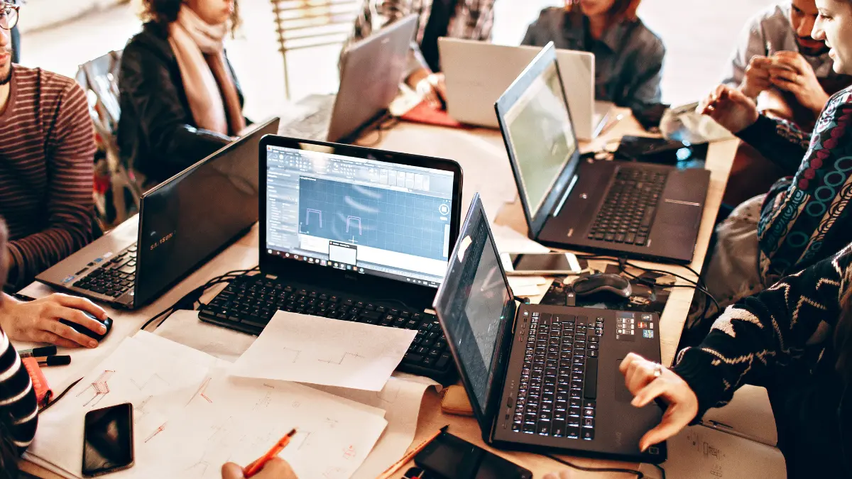 Third-party collaboration framework displayed during a group tech session using multiple laptops and diagrams.
