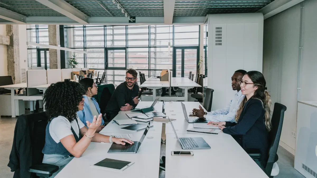 Vendor risk management tools discussed by a diverse business team collaborating around a long office table.