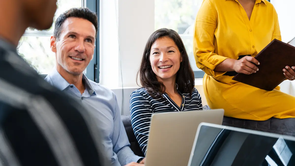 Emission frameworks discussed by diverse professionals during a collaborative team meeting in a bright office.