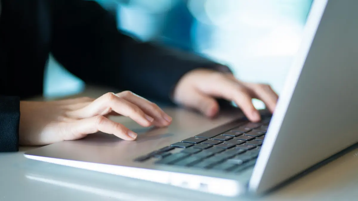 Risk management automation software being accessed by a professional typing on a laptop