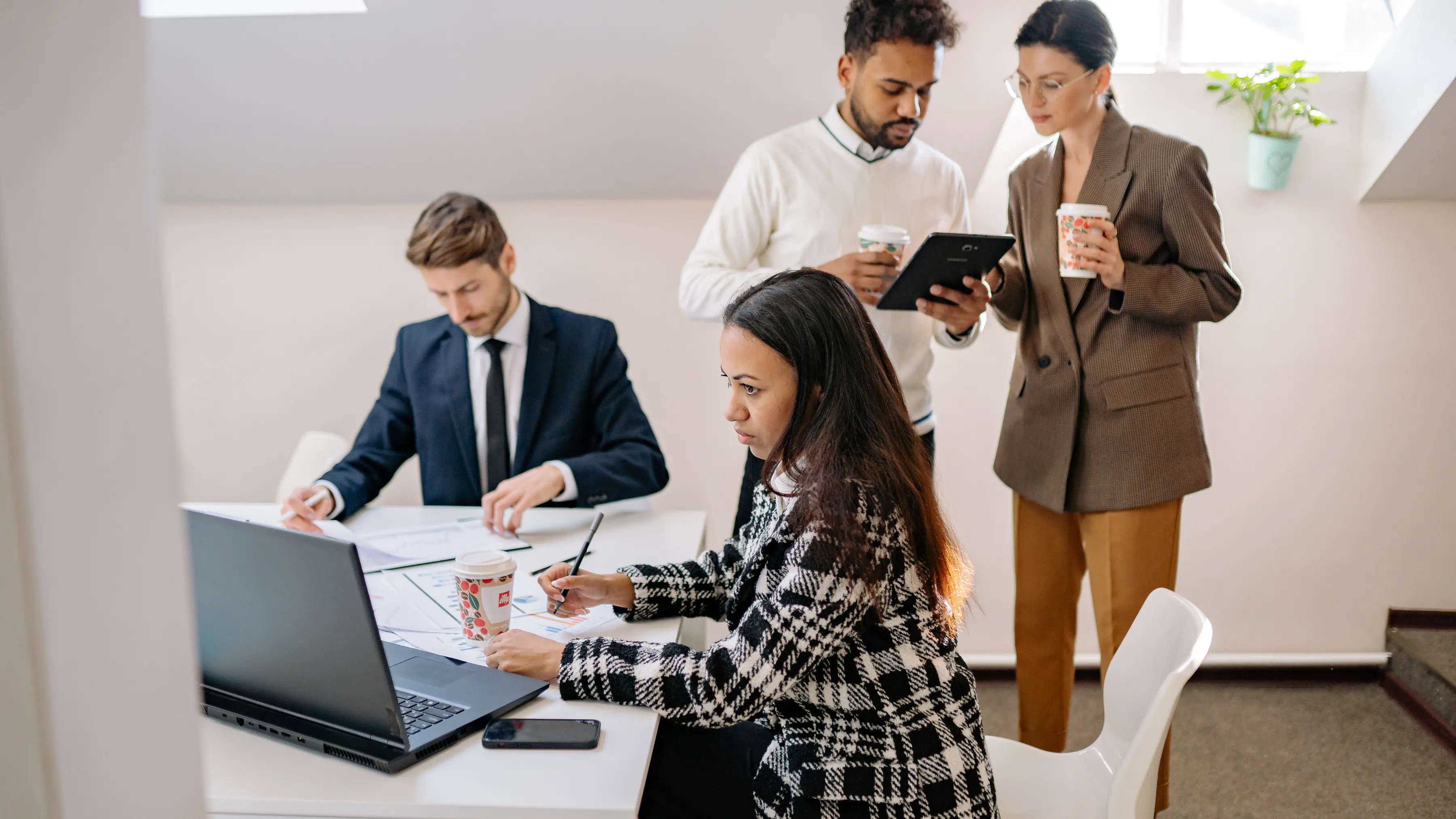 business risk strategy featuring professionals collaborating with laptops, reports, and tablets to evaluate company risk plans
