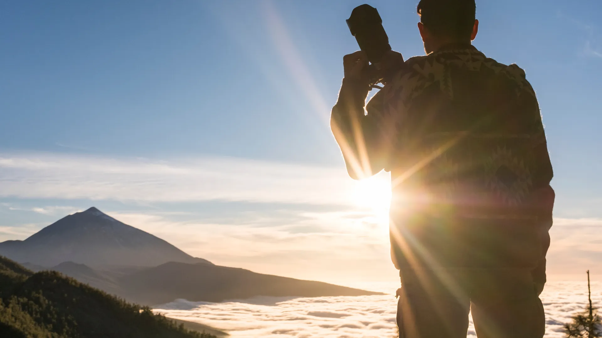 A hiker captures the sunset view over mountains, symbolizing adventure, freedom, and the beauty of nature photography.