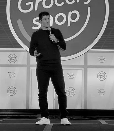 A man standing on a stage holding a microphone.