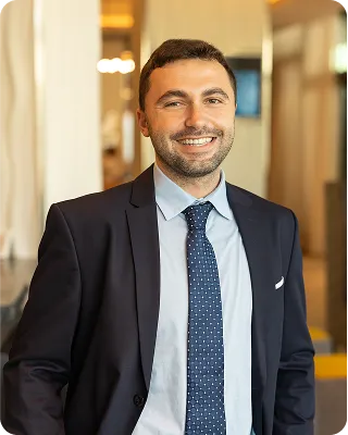A portrait of a smiling man in a suit and tie.