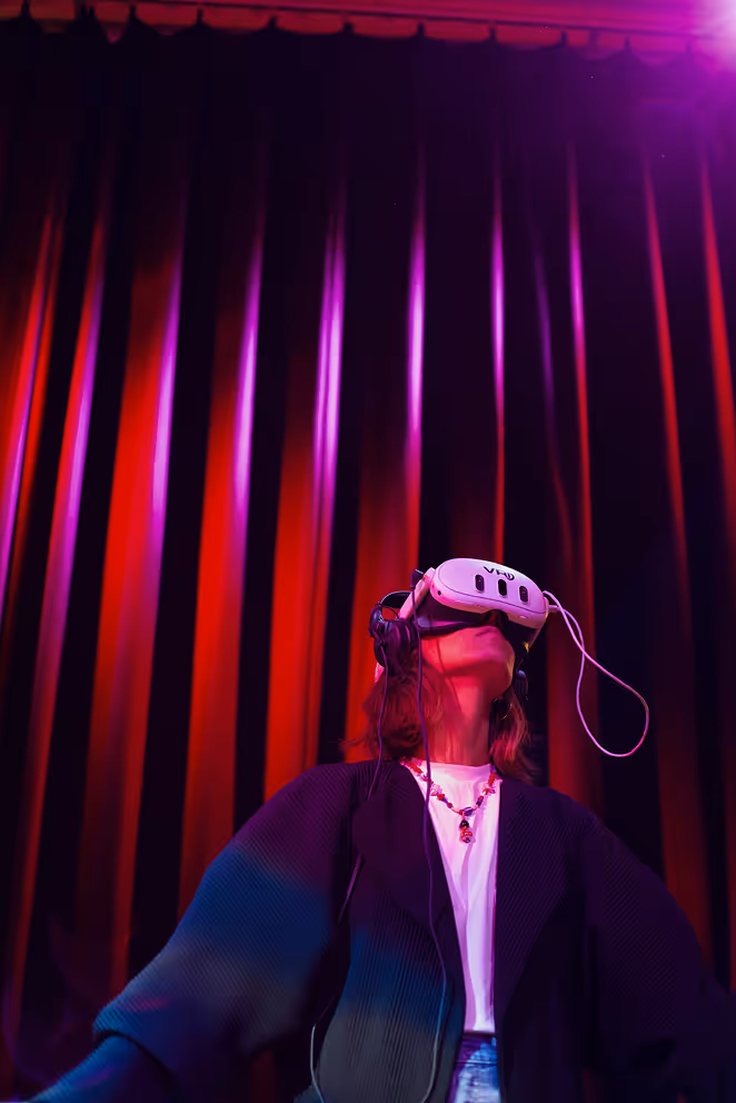 Een persoon is in vr, voor een groot rood gordijn.