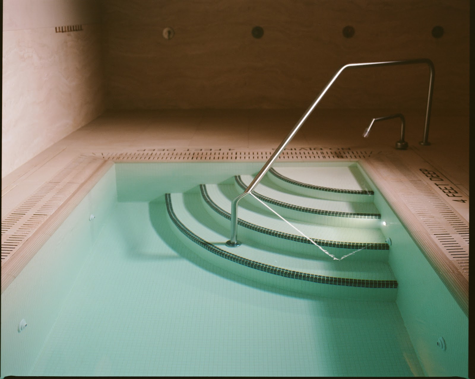 Plunge pool steps from above — teal water