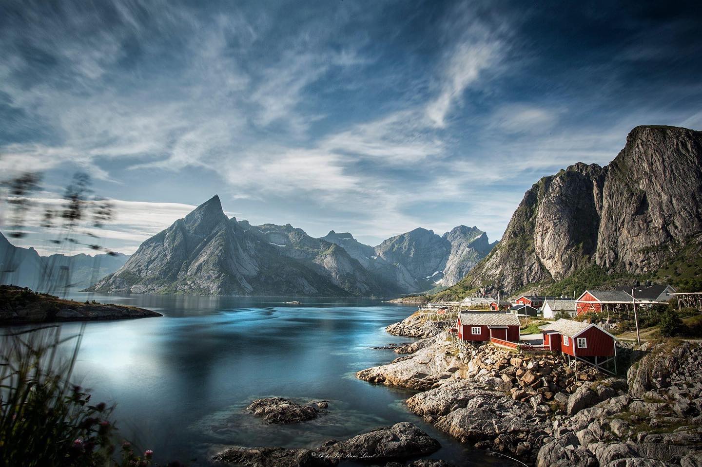 Beutiful Fjord with small houses near water and mountain in the back.