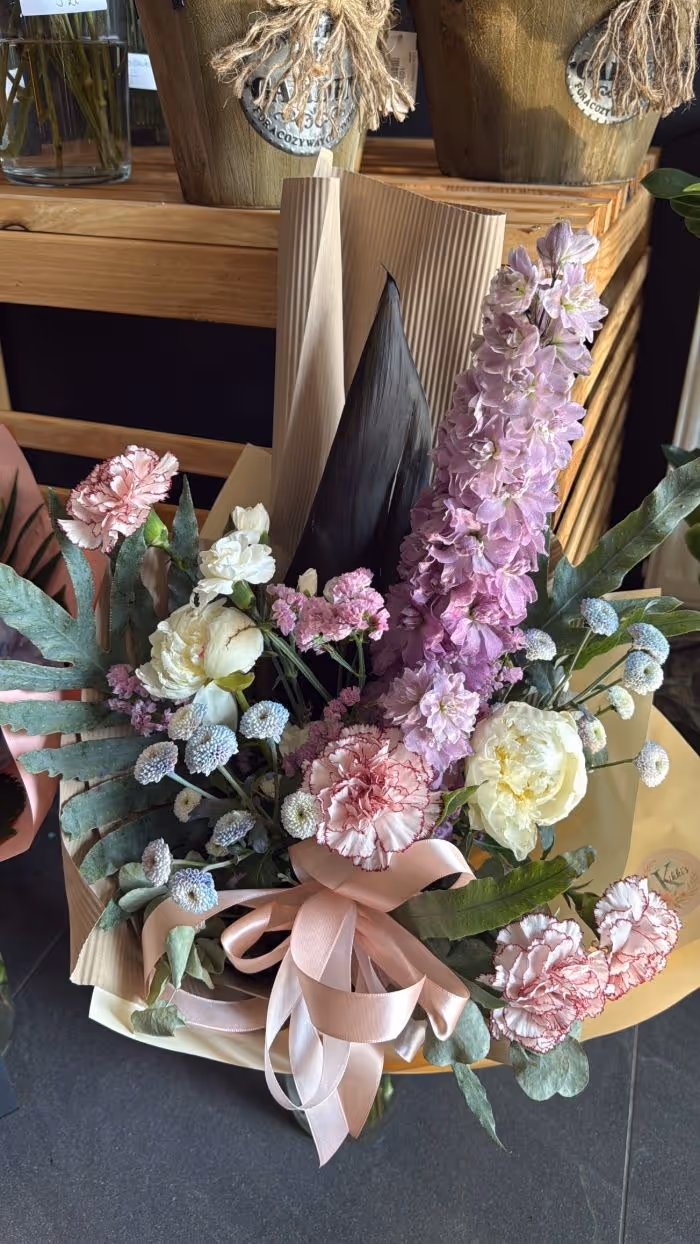 Kompozycja z dzikich kwiatów w stylu botanicznym z różowymi akcentami.