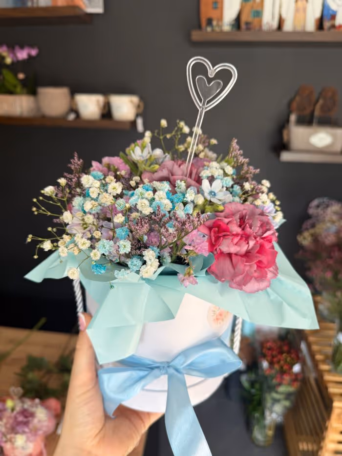 Mały, uroczy bukiet w pastelowych kolorach z goździkami i gipsówką.