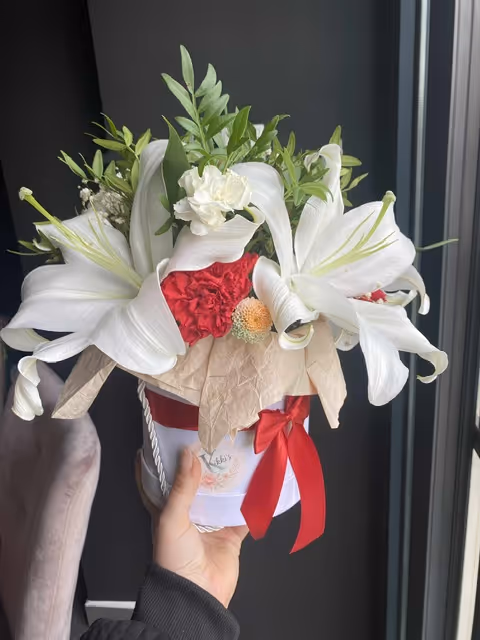 Elegancki biały bukiet z liliami, eustomą i czerwonym akcentem.