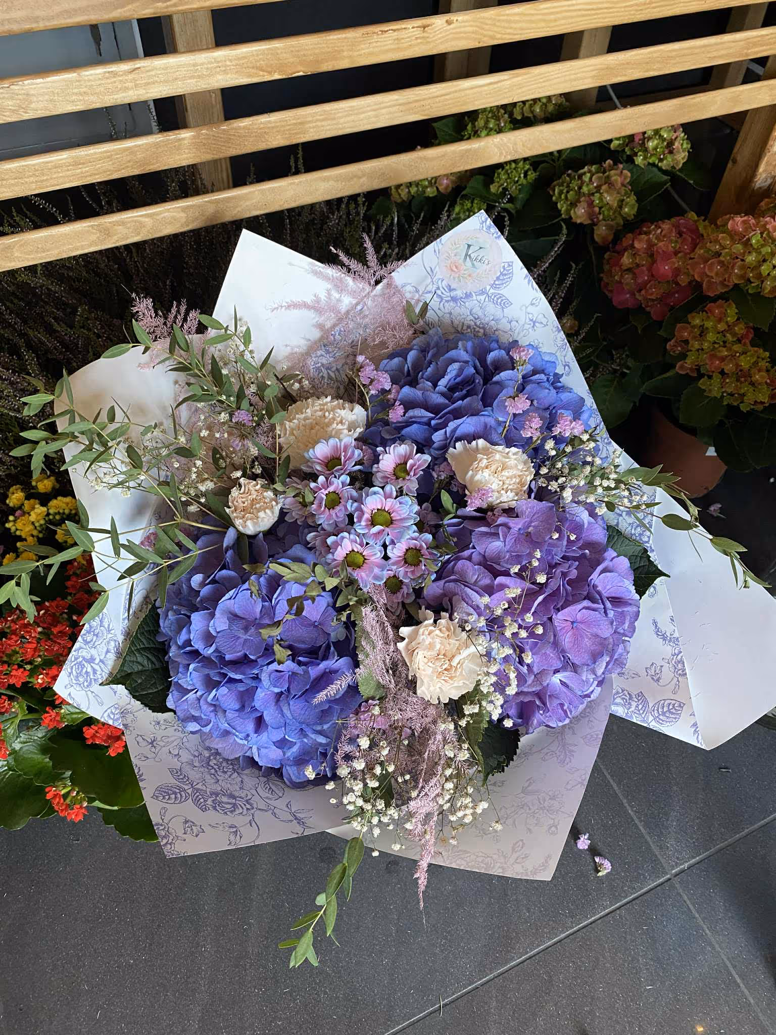 Pastelowe bukiety w odcieniach fioletu i lawendy, ozdobione gipsówką i zapakowane w delikatny papier.