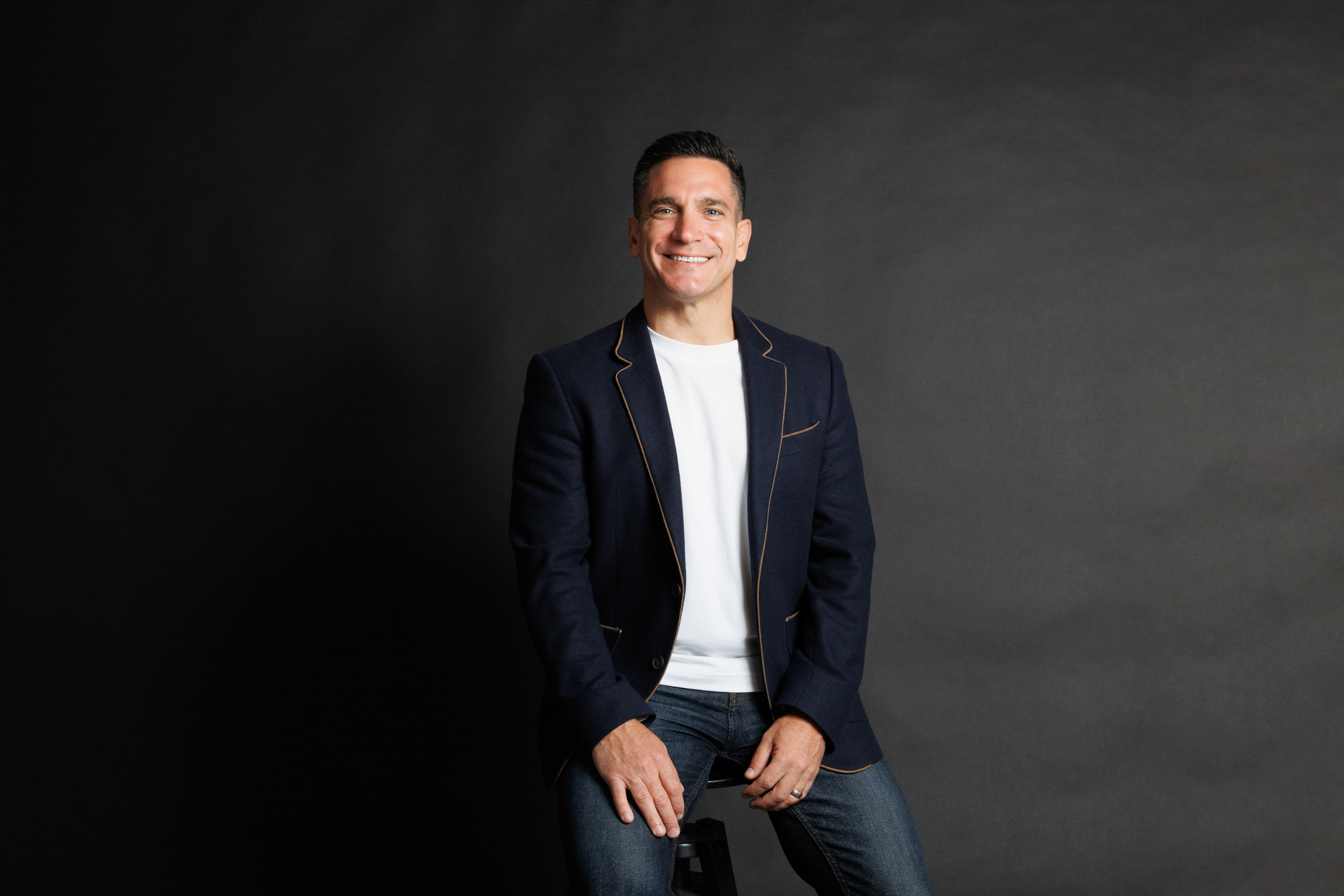 Chris Tonich, Perth real estate agent, smiling in a suit at City Beach