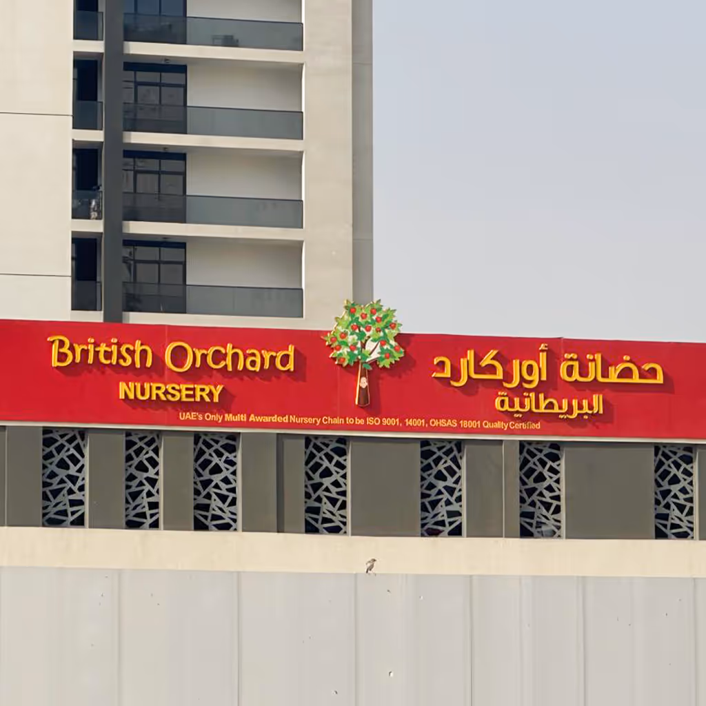 Sign for British Orchard Nursery with a tree logo, located on a building facade.