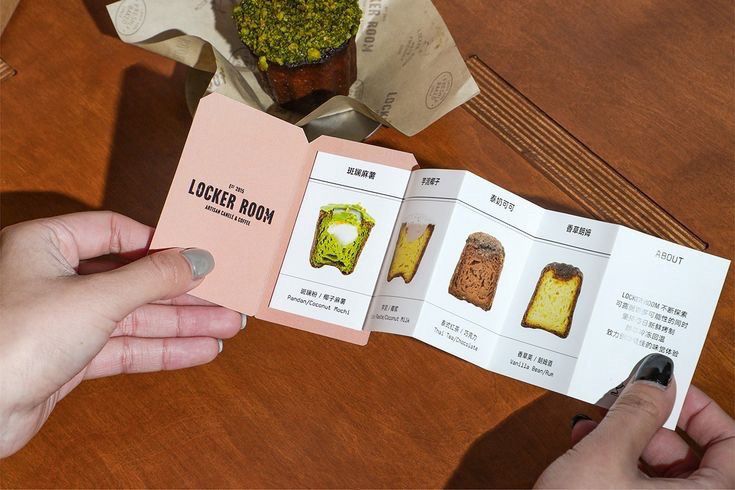 This may contain: a person holding an open book on top of a wooden table