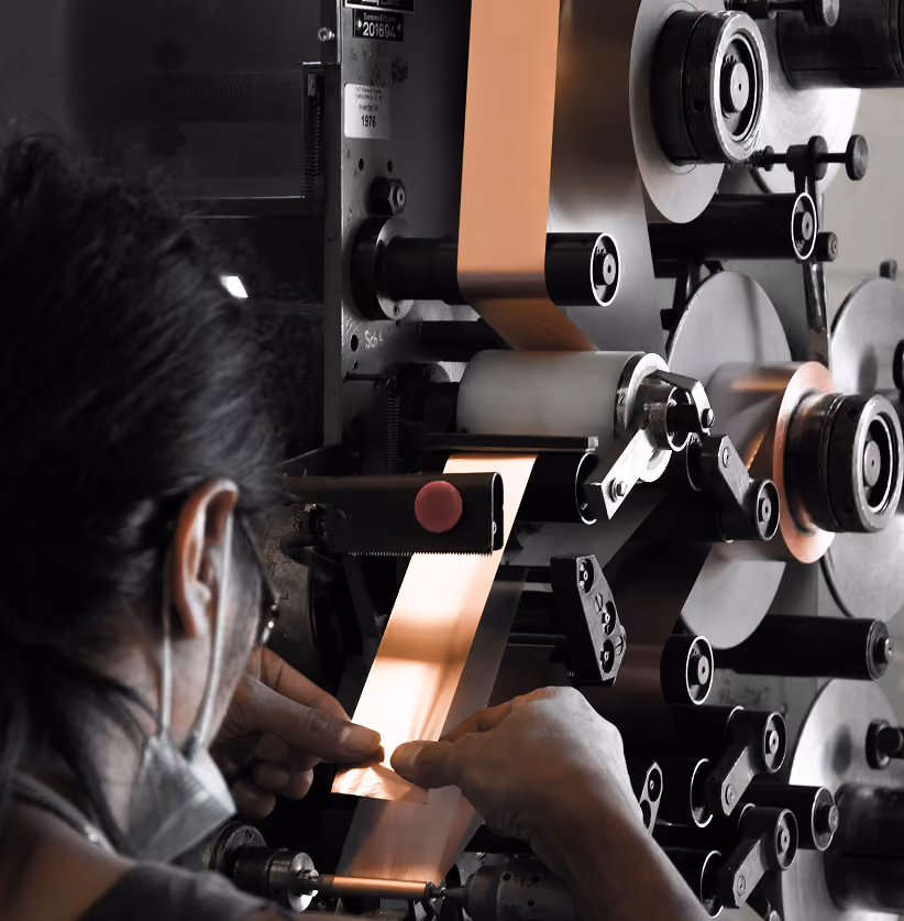 Employee operating a winding machine in production