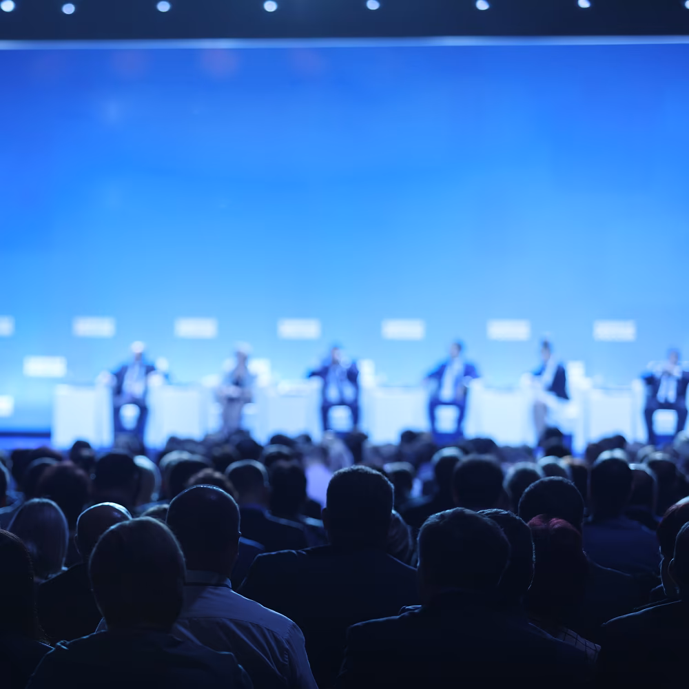 Business conference showing a panel of investment professionals and service providers speaking to an audience.