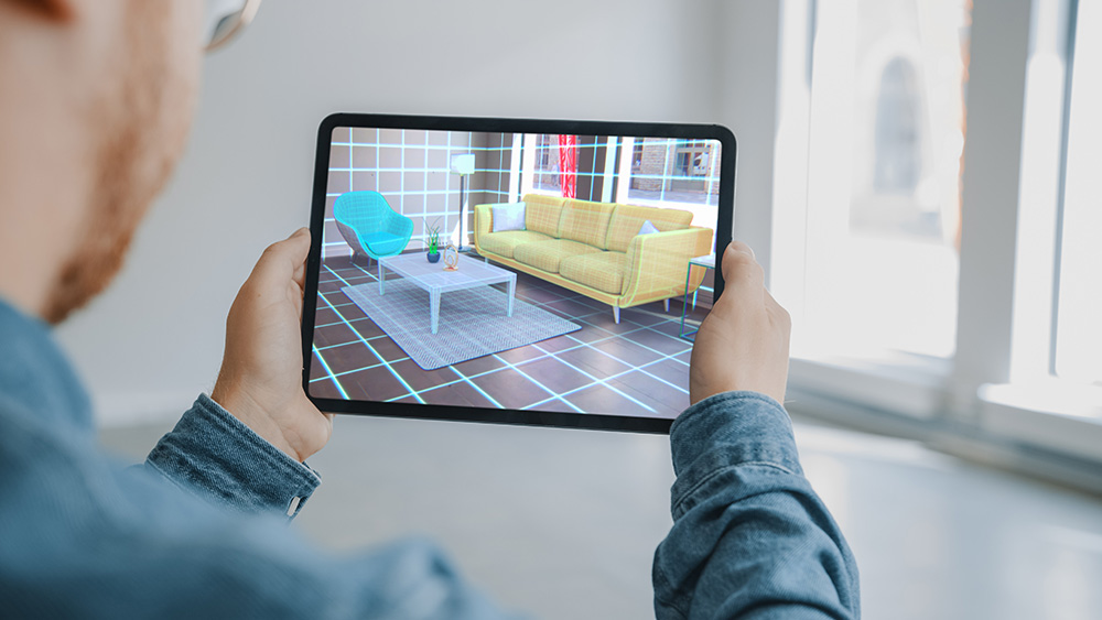Person using augmented reality on their Ipad to see what furniture would look like in their living room