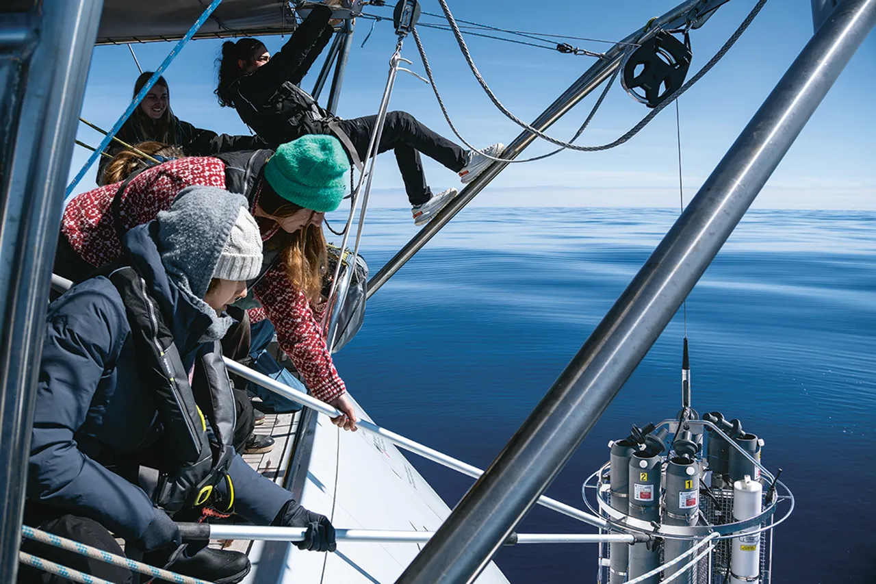 An einem außergewöhnlich windstillen Tag lässt die Crew eine CTD-Rosette, eine mit Sensoren ausgestattete Forschungssonde, ins Wasser