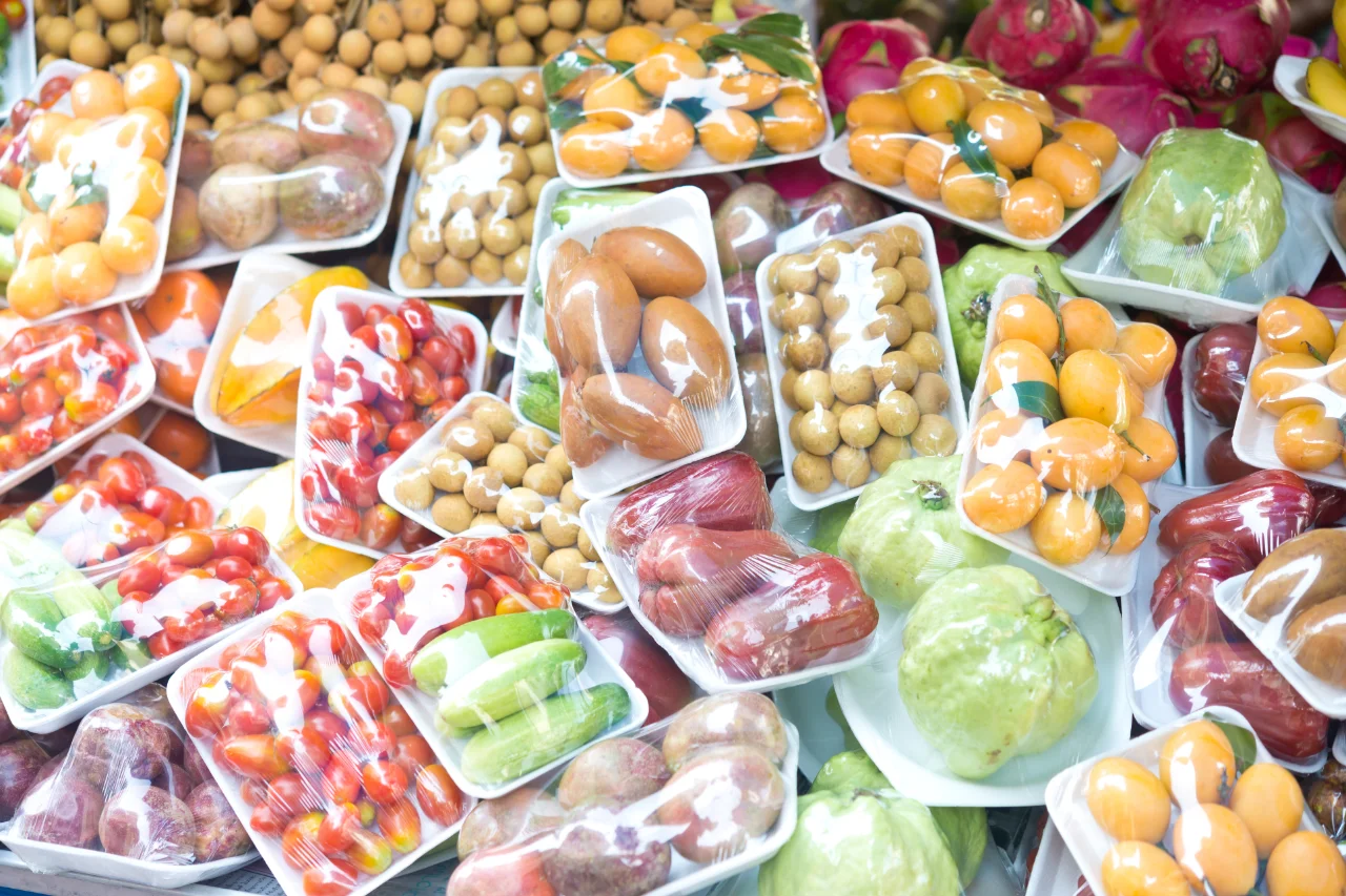 Große Mengen an Obst und Gemüse in Plastikfolie auf Styroporschalen verpackt