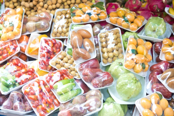 Große Mengen an Obst und Gemüse in Plastikfolie auf Styroporschalen verpackt