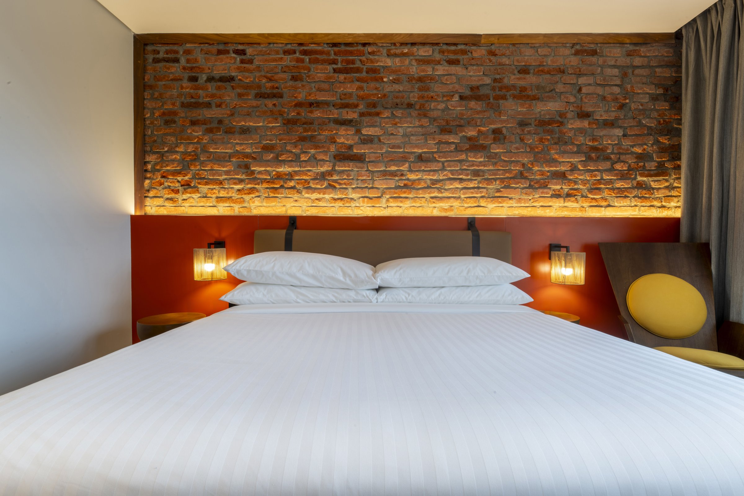 King bed and exposed brick feature wall in a guest room at Zaria Court Kigali
