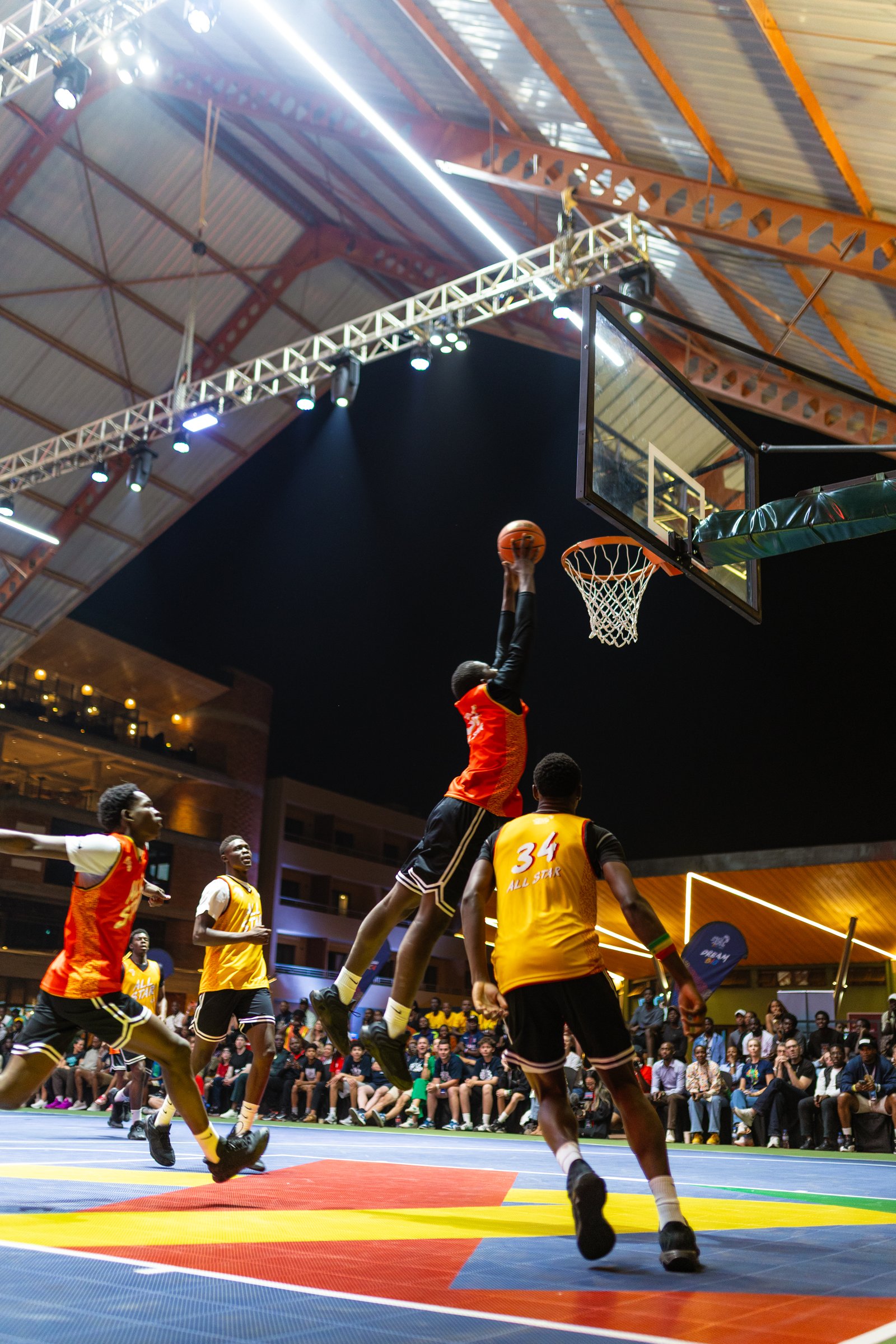 Players competing during a basketball game on the multi-purpose court at Zaria Court Kigali