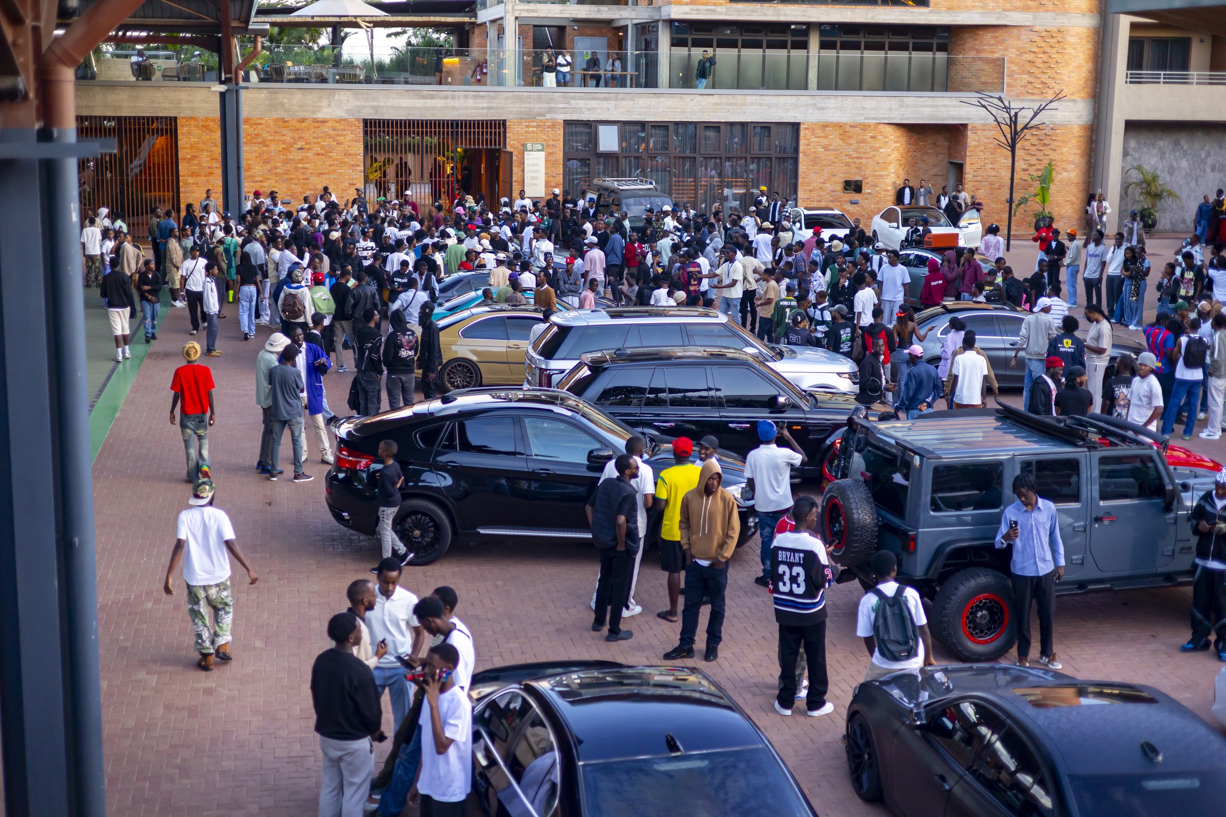 Crowds admiring cars at a Cars and Coffee meet at Zaria Court Kigali