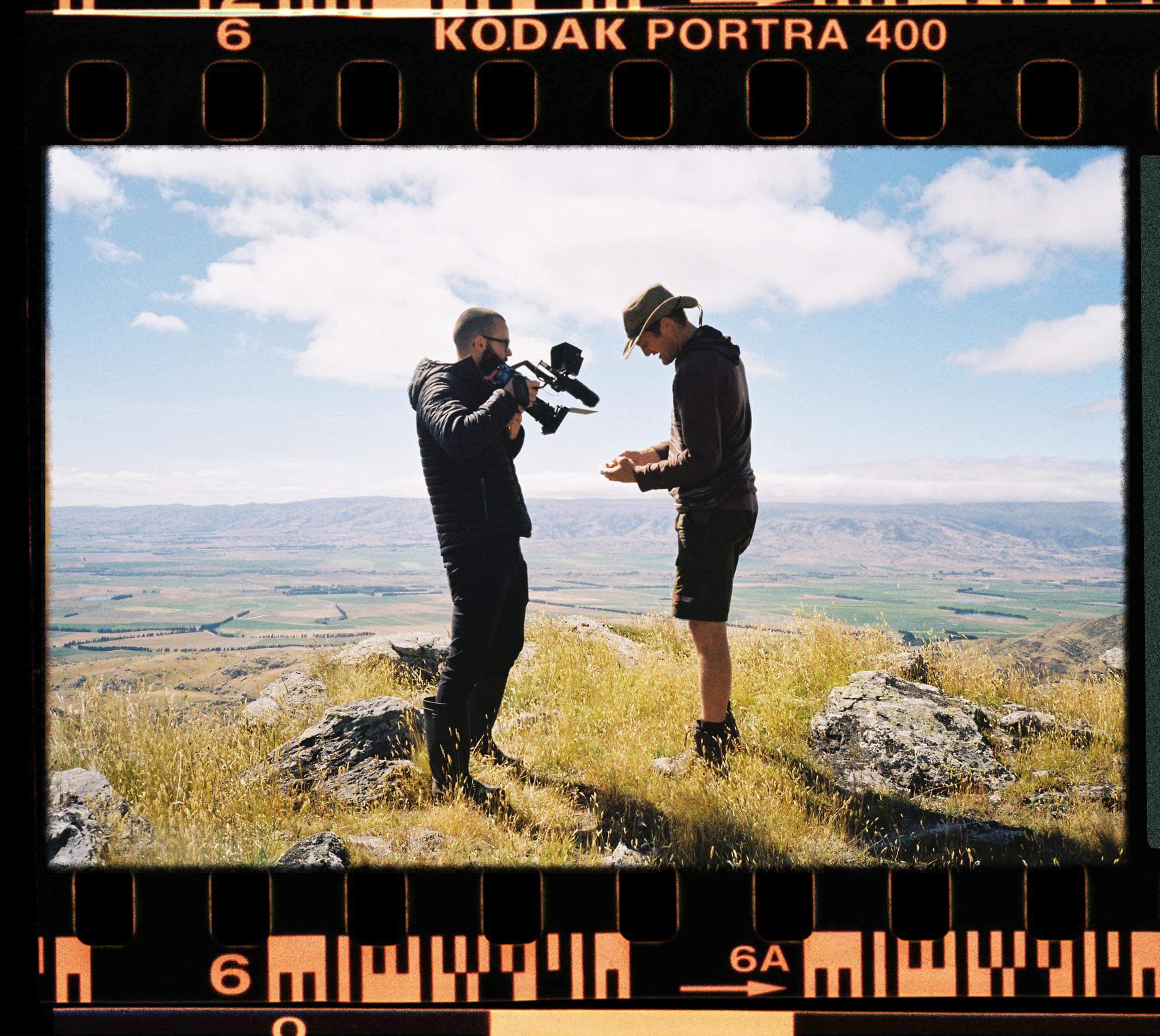 Bradon Filming a farmer holding some grass to the lens 