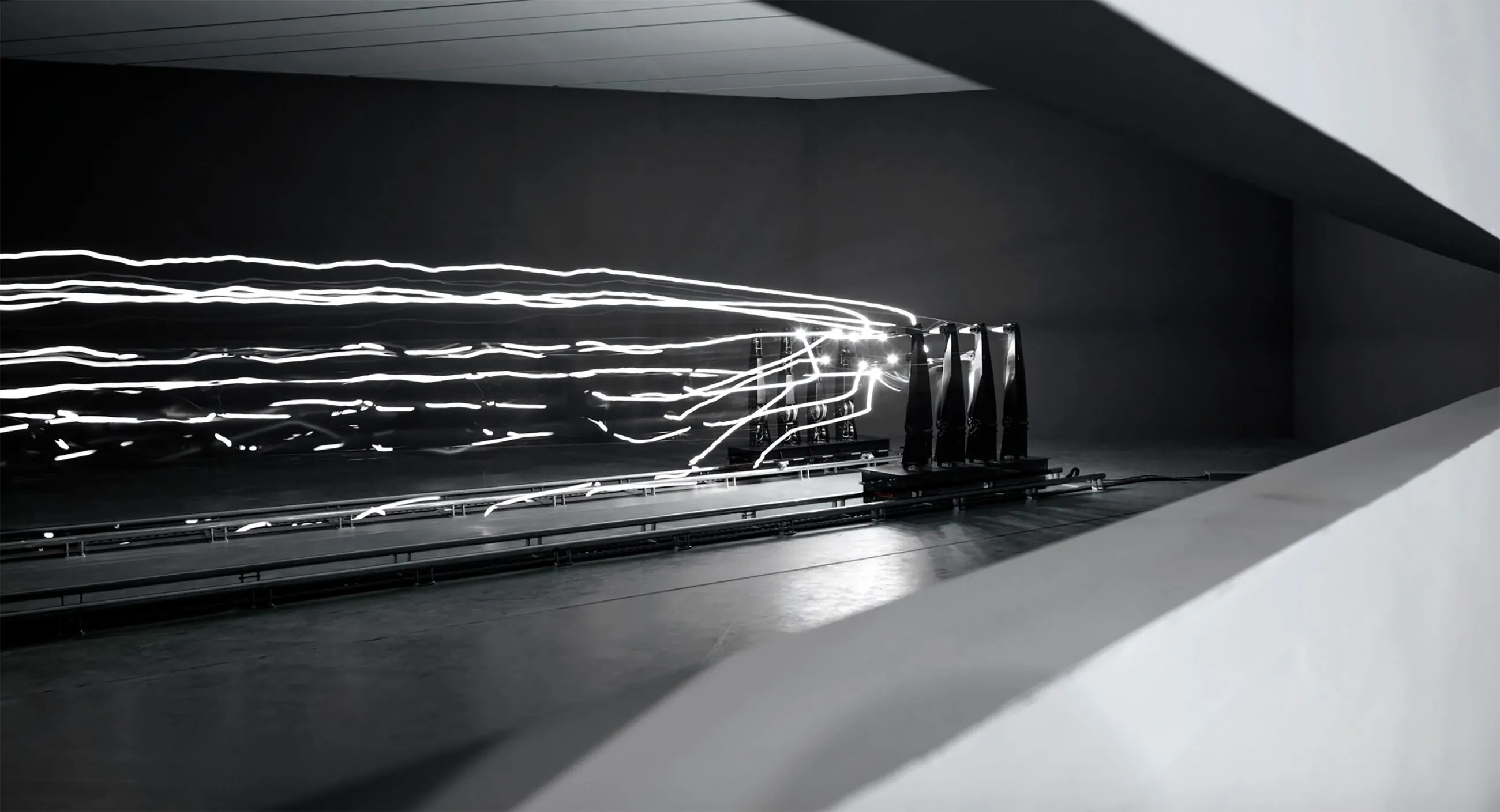 Black and white image of LED lights coming out of a machine.
Photo credit: Random International
