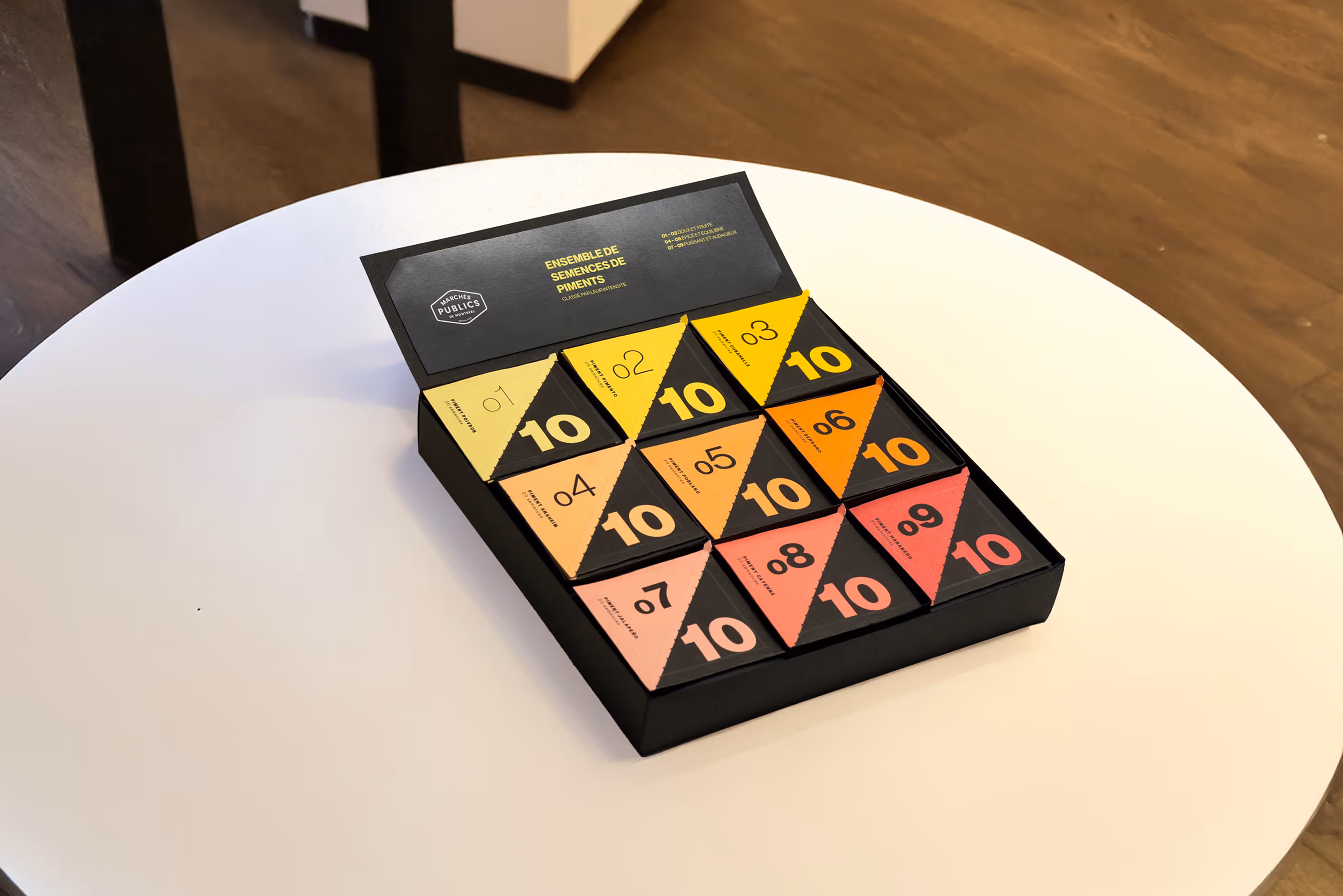 Open black display box showing a colorful collection of triangular pepper seed packets, each marked with a different number from 01 to 10.