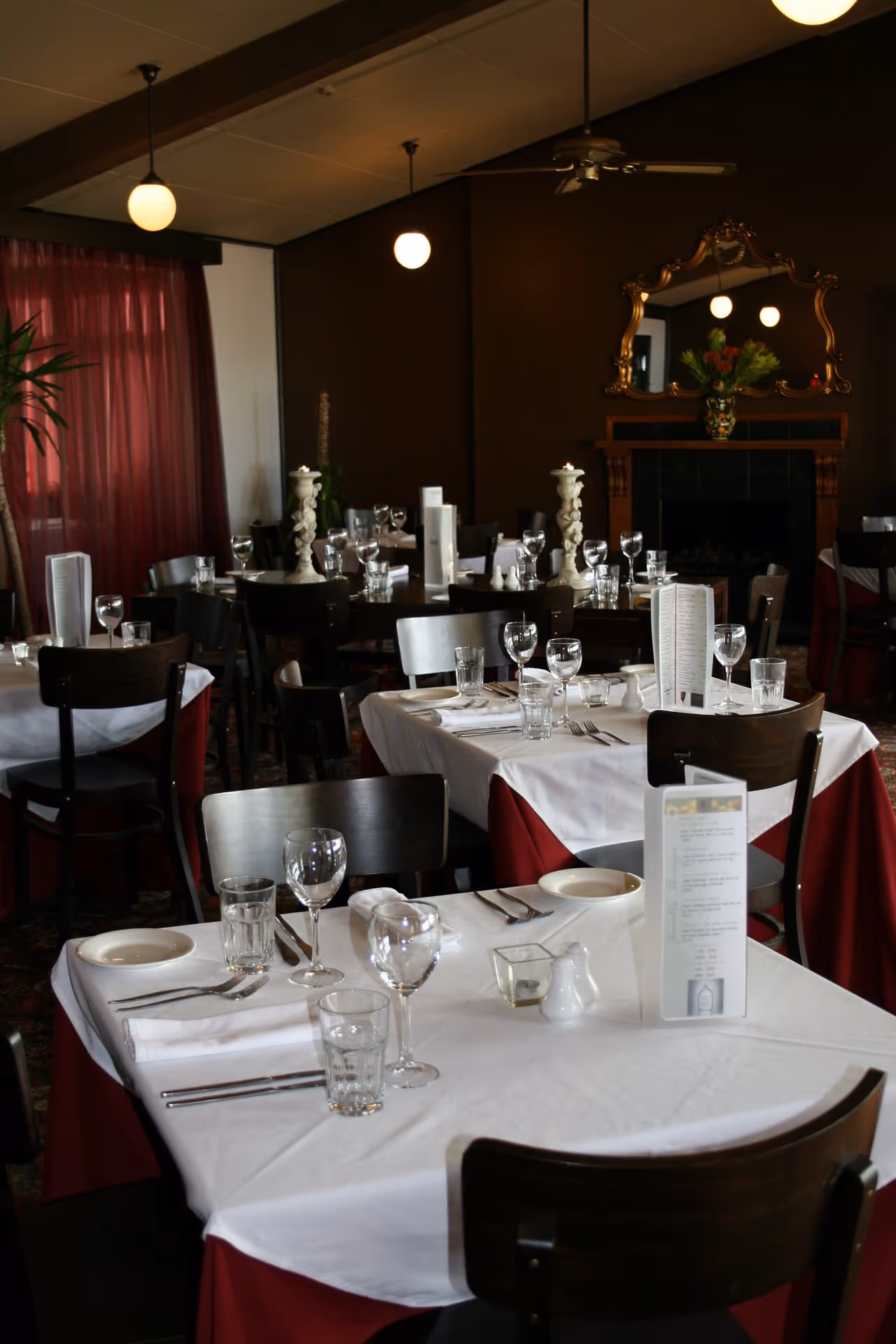 Elegant restaurant dining area with neatly set tables, red accents, and a warm, inviting atmosphere.