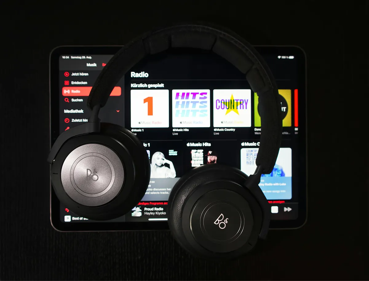 Headphones resting on a tablet showing a radio streaming app
