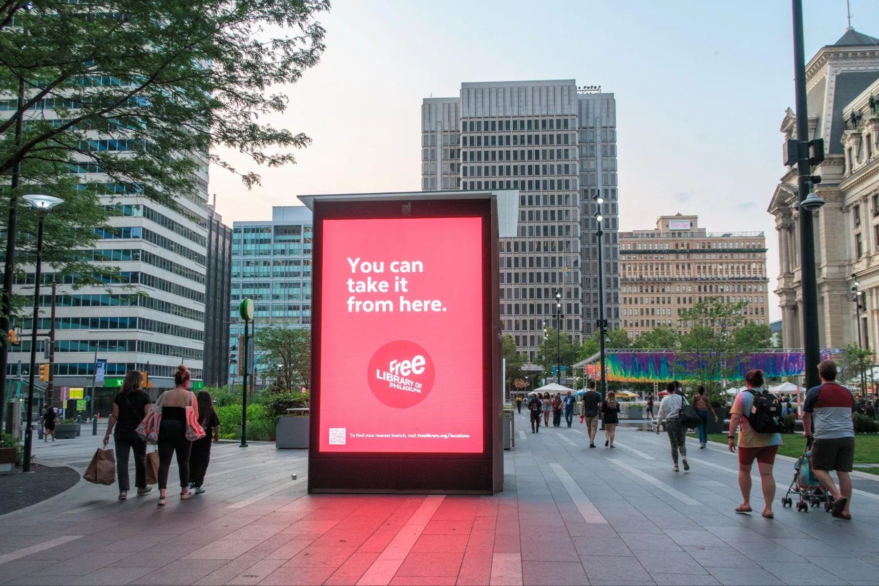 Digital billboard on a busy city sidewalk