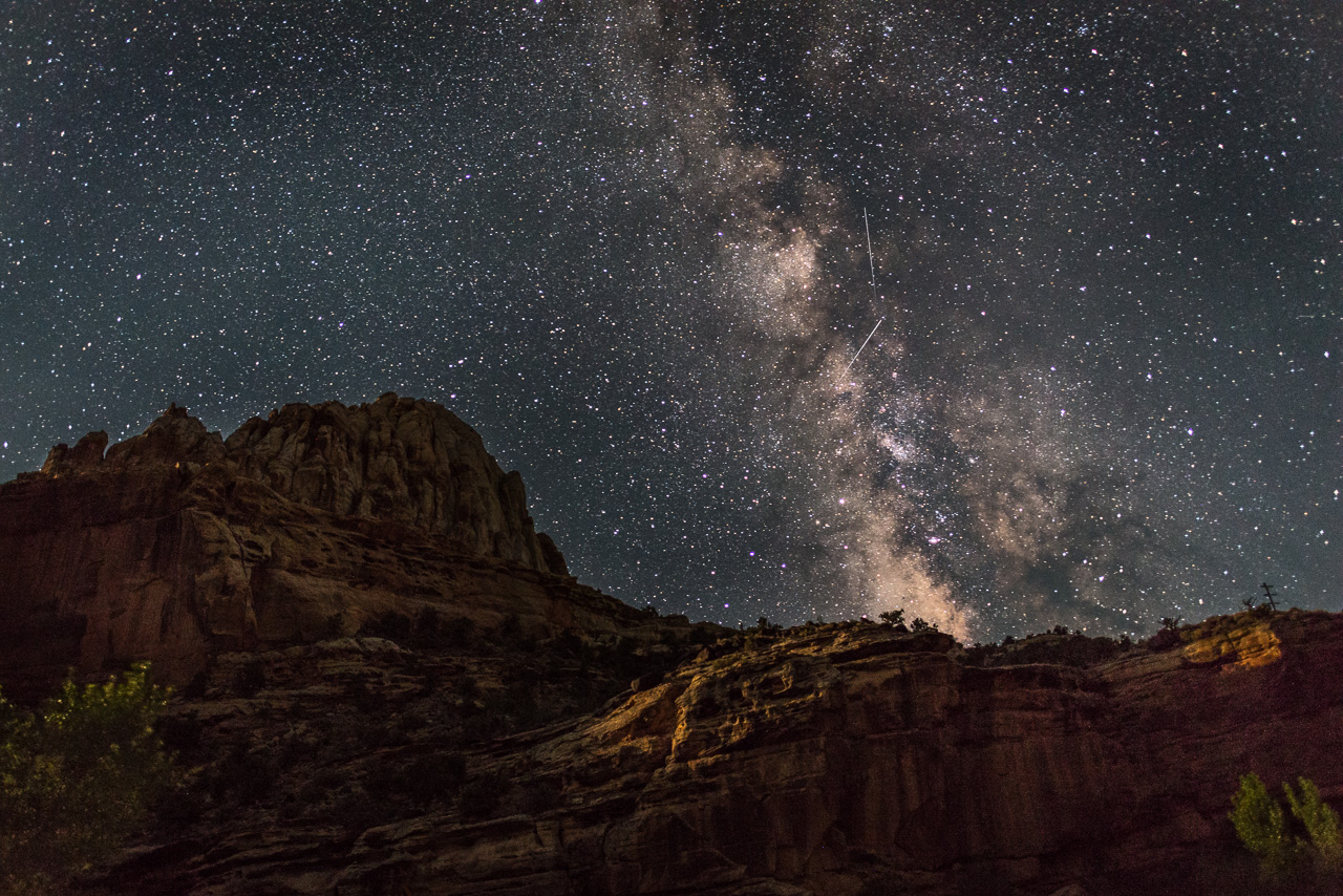 Milky Way visible above red rock cliffs in Capitol Reef National Park, showcasing the park’s dark night skies