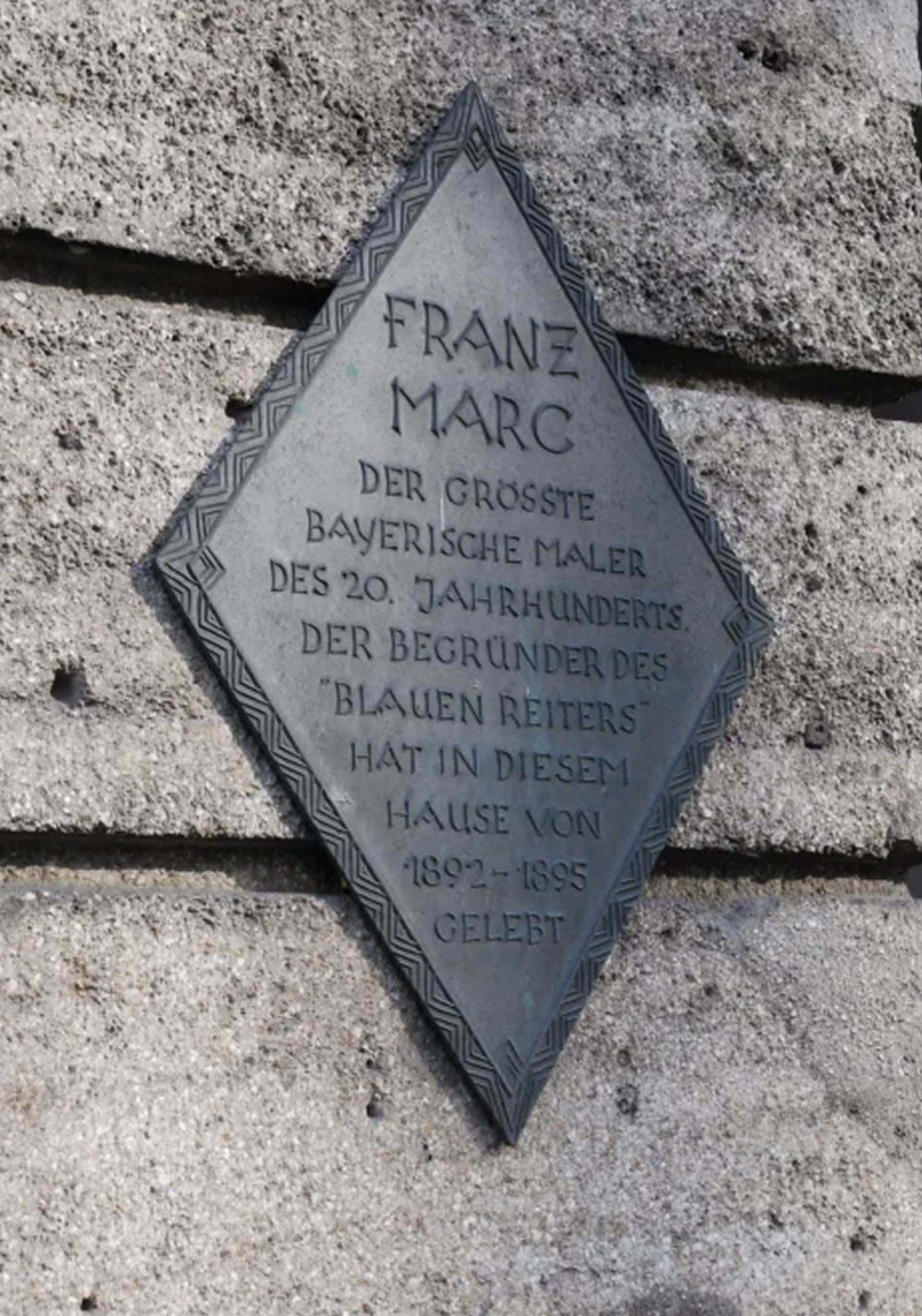 Eine an der Hauswand angebrachte Plakette, die darüber informiert, dass Franz Marc hier gewohnt hat.