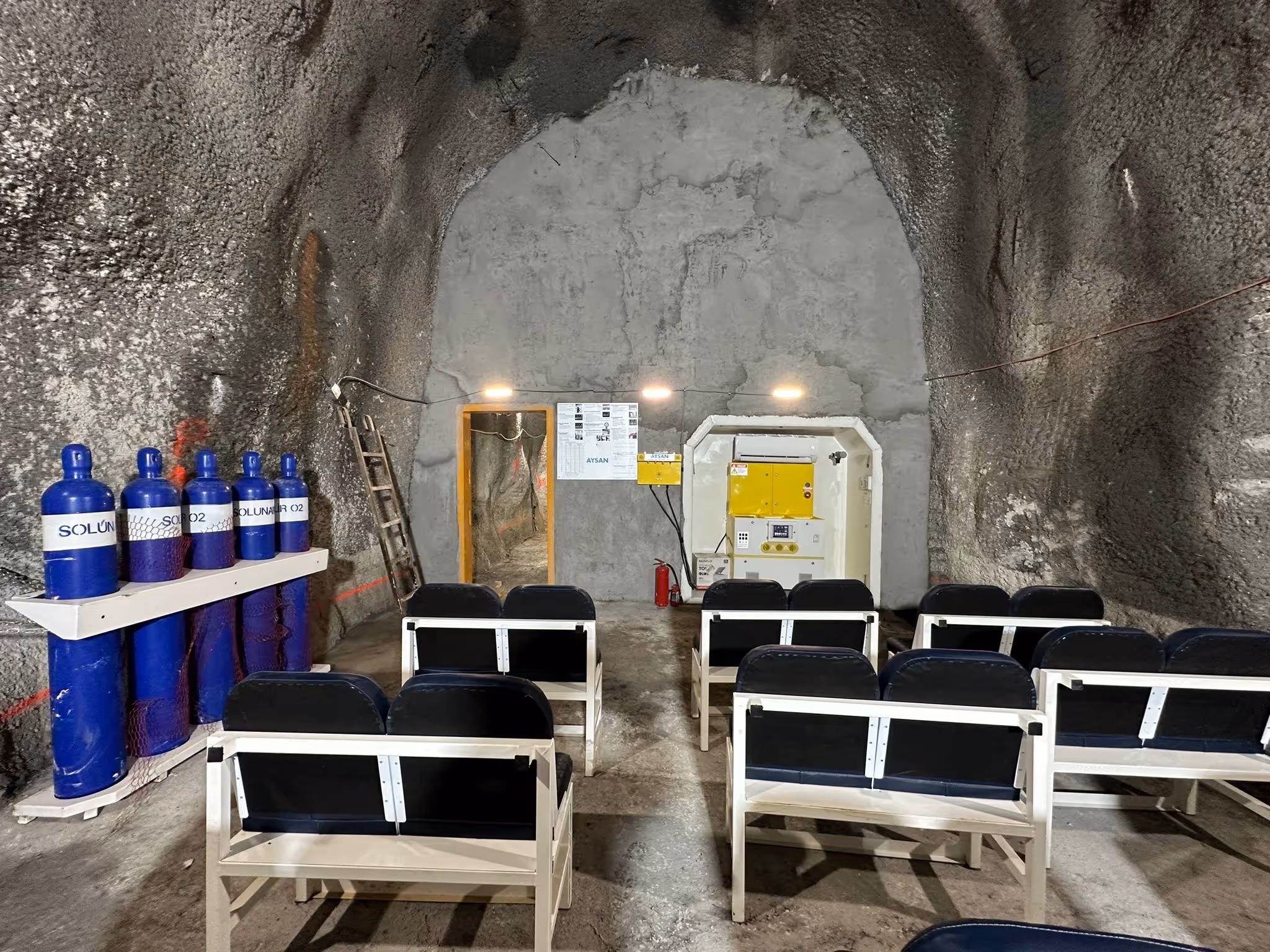 Underground bunker laboratory with seating, gas cylinders, and monitoring equipment setup